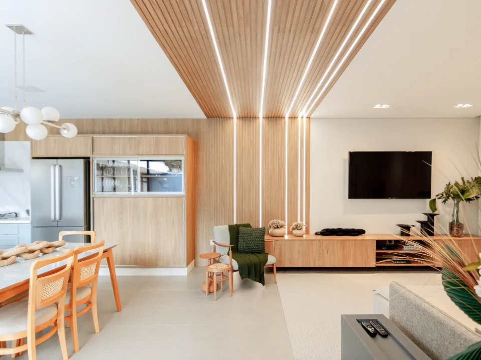 Sala de estar com painel ripado, forro de madeira, iluminação linear embutida e rack sob medida